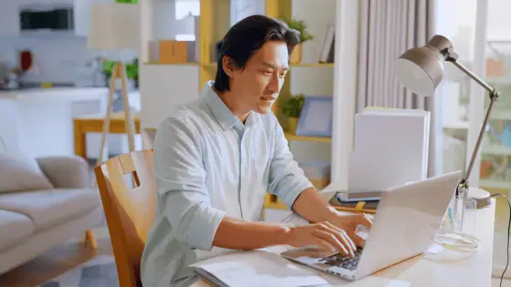 A man working on his laptop at a desk.